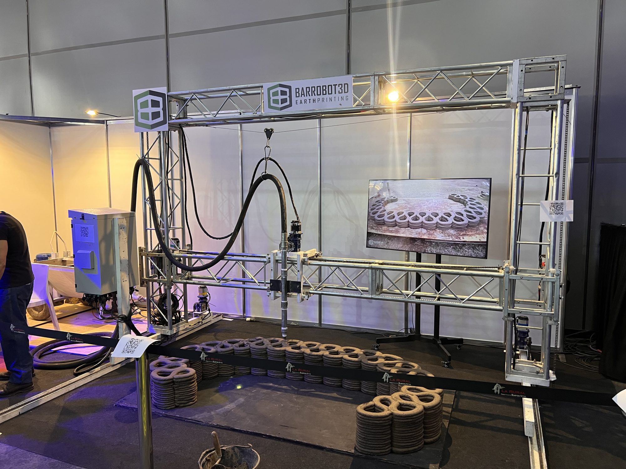 El stand de Barrobot3D en la Expo 3D Argentina: la máquina, la pantalla encendida y los anillos impresos en el piso