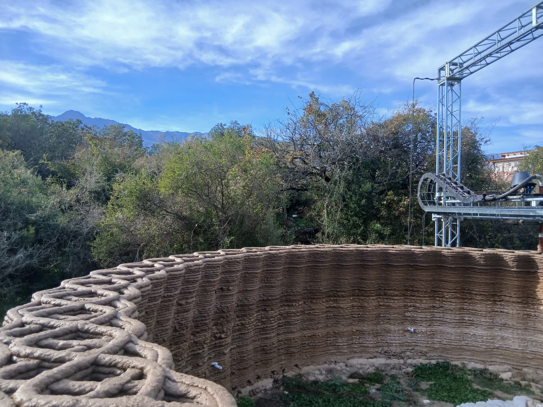 Un muro impreso en tierra cruda, en el paisaje serrano
